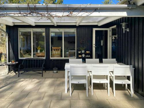 ein weißer Tisch und Stühle auf einer Terrasse in der Unterkunft Family House With Large Garden Near Ebeltoft in Ebeltoft