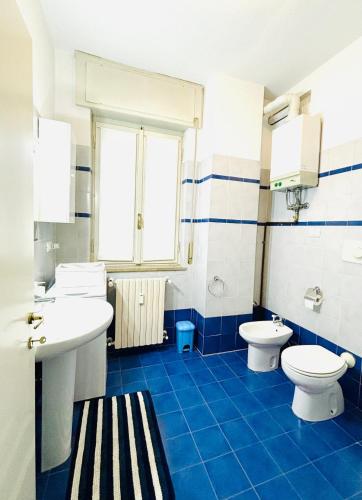 a blue and white bathroom with two toilets and a sink at Appartamento Crema centro in Crema