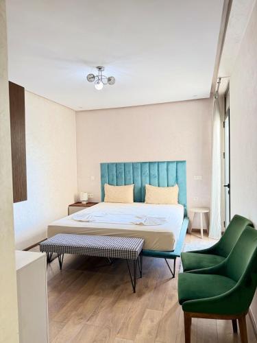 a bedroom with a bed and a green chair at Agadir bay luxury in Agadir
