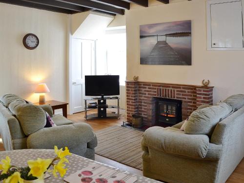 a living room with two couches and a fireplace at Rockville Cottage - 24376 in Bempton