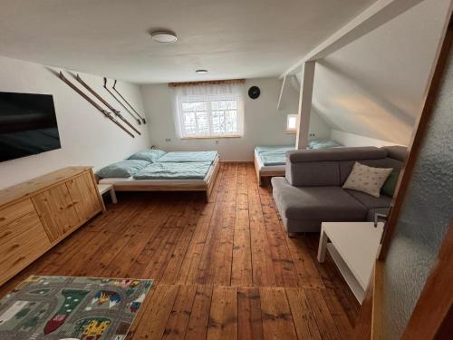 a living room with two beds and a couch at Chaloupka Příchovice in Kořenov