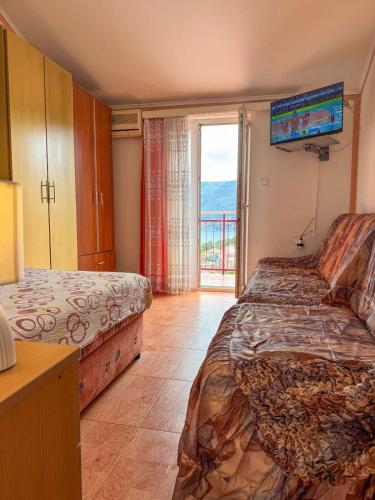 a hotel room with two beds and a balcony at Apartmani Sunny Marić in Herceg-Novi