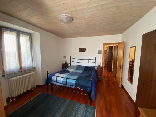 a bedroom with a bed and a wooden floor at Piccolo Paradiso in Piuro