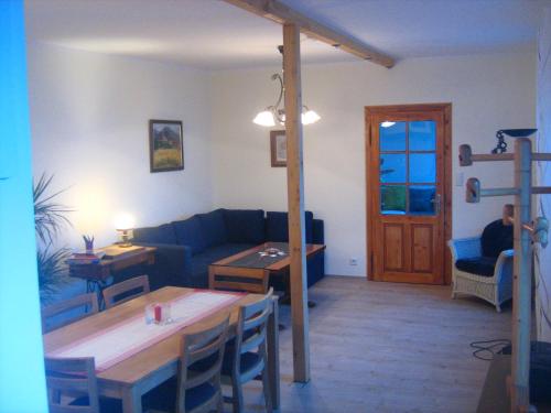 a living room with a blue couch and a table at Das Haus am See in Grundlsee