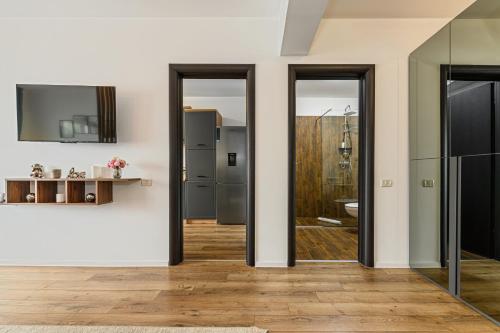 ブラショヴにあるMountain Breeze Luxury Apartment AC & Parcare Privatăの引き戸と冷蔵庫付きのキッチン