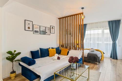 ブラショヴにあるMountain Breeze Luxury Apartment AC & Parcare Privatăのリビングルーム(ベッド1台、青いソファ付)