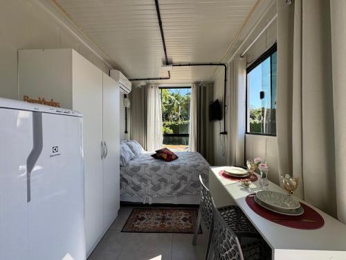 a kitchen with a table and a bed in a room at Charmoso e bem localizado! in Tijucas