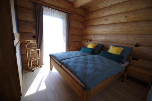 ein Schlafzimmer mit einem Bett in einer Blockhütte in der Unterkunft Blockhaus Eifelstern in Blankenheim
