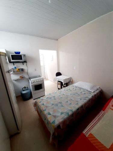 a small bedroom with a bed and a kitchen at Espaço inteiro in São Caetano do Sul