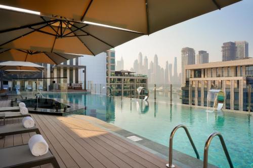 a swimming pool with a view of a city skyline at Mileo Hotel The Palm in Dubai