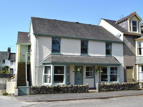 a white house with a blue door on a street at Dairy Lodge in Keswick
