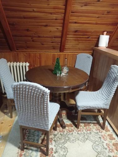 un tavolo di legno con sedie e un albero di Natale sopra di Forest Escape a Pale