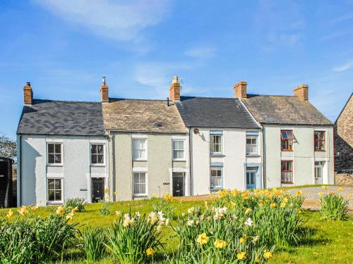 a large house with flowers in front of it at Goat Street Cottage in St. Davids