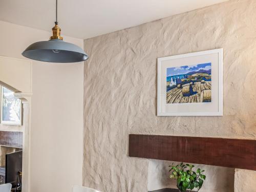 a pendant light hanging over a fireplace in a living room at Goat Street Cottage in St. Davids