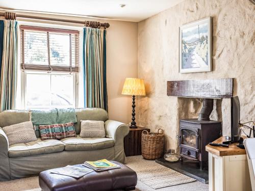 ein Wohnzimmer mit Couch und Kamin in der Unterkunft Goat Street Cottage in St. Davids