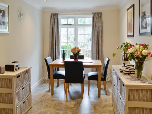 a dining room with a table and chairs and a window at Riverside Cottage - B6859 in Saint Cleer