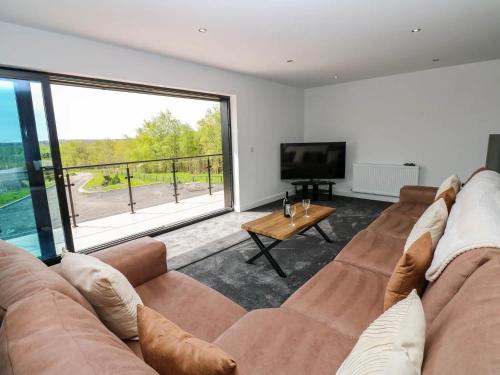 a living room with a couch and a large window at Silverbirch Cottage - 3 Bedrooms - Sleeps 6 in Frizington