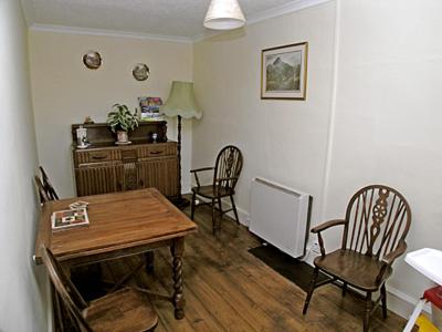 a dining room with a wooden table and chairs at Is Helen Cottage in Caernarfon