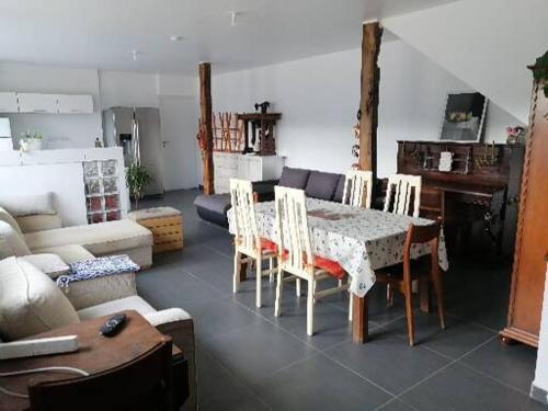 een woonkamer met een tafel, stoelen en een bank bij A 100 m de la grande plage à Saint-Lunaire in Saint-Lunaire
