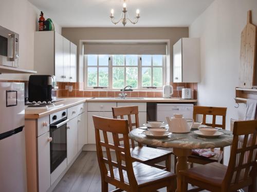a kitchen with a table and chairs and a sink at The Cottage At Canefield Farmhouse in Mottisfont