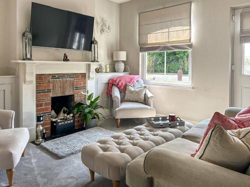 un salon avec un canapé et une cheminée dans l'établissement Lavender Cottage, à Frinton-on-Sea