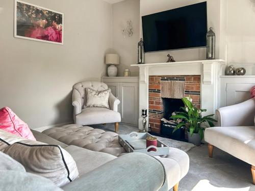 un salon avec un canapé et une cheminée dans l'établissement Lavender Cottage, à Frinton-on-Sea