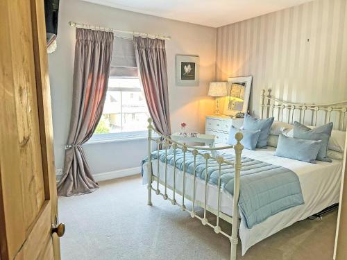 a bedroom with a bed and a window at Lavender Cottage in Frinton-on-Sea