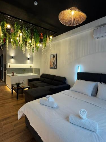 a bedroom with a bed and a living room at Botanica Noir Jacuzzi Valaoritou in Thessaloniki