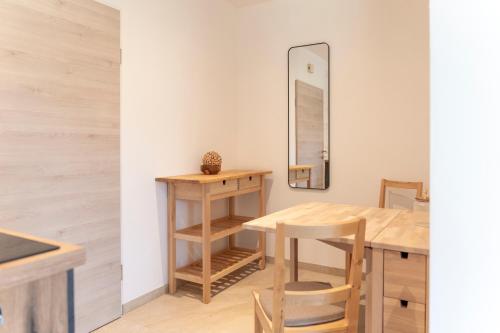 cocina con mesa, sillas y espejo en Das Nest, en St. Wolfgang