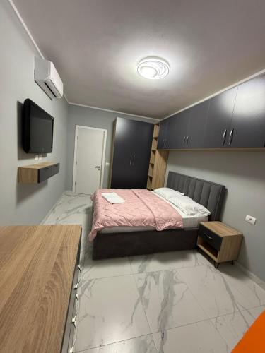 a bedroom with a bed and a flat screen tv at Luxury Apartment Orikum in Orikum