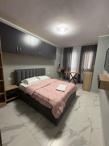 a bedroom with a bed with a pink comforter at Luxury Apartment Orikum in Orikum