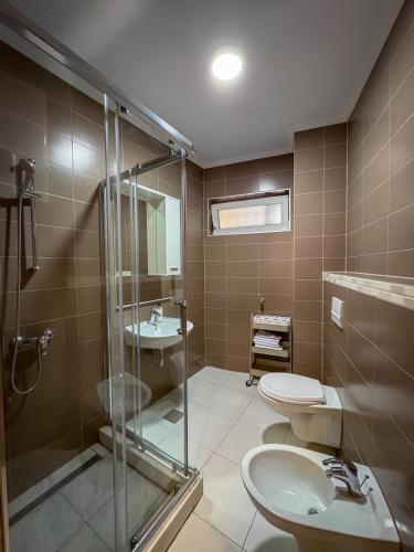 a bathroom with a shower and a toilet and a sink at Residence Mahala - Boutique Stay Near Old Town in Sarajevo