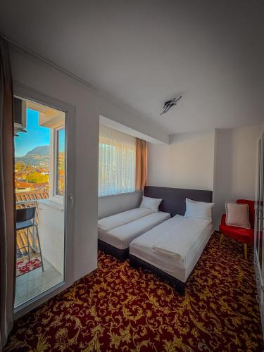 a bedroom with two beds and a large window at Residence Mahala - Boutique Stay Near Old Town in Sarajevo