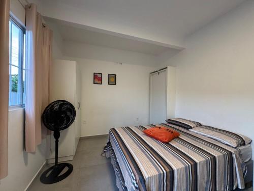 a bedroom with a bed with a orange pillow on it at Apto térreo em Tijucas n 04 in Tijucas