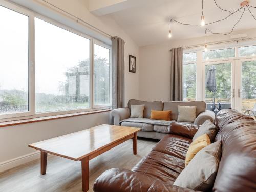a living room with a couch and a coffee table at The Barn-Uk32860 in Alltwen