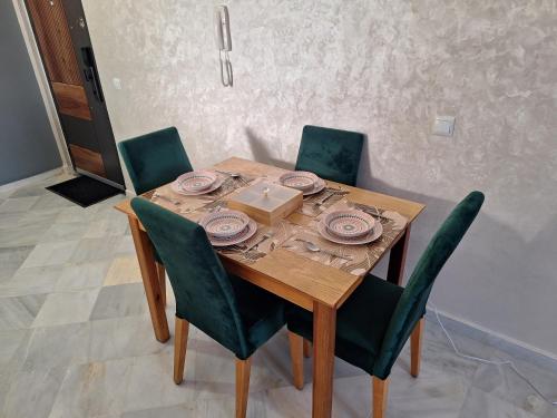 a wooden table with chairs and a box on it at Appartement Lazziz in Tangier