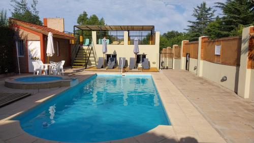 une piscine avec des chaises et une maison dans l'établissement Cabañas Alünmew, à Juana Koslay 