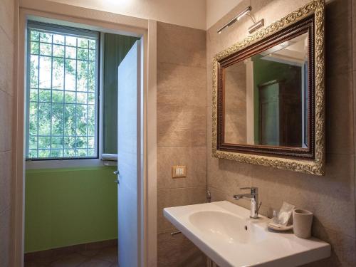 y baño con lavabo y espejo. en Villa Camurana, en Medolla