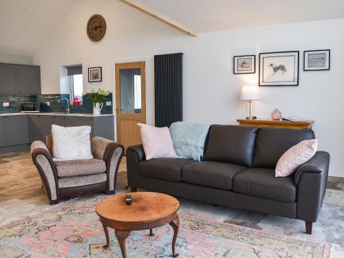 a living room with a couch and a table at Branwen in Llanfachraeth