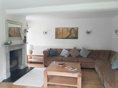 a living room with a brown couch and a coffee table at Greenlands Farmhouse in Barmby on the Moor