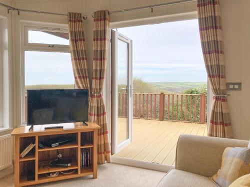 West DownにあるGrandma's Stick Houseのリビングルーム(薄型テレビ、バルコニー付)
