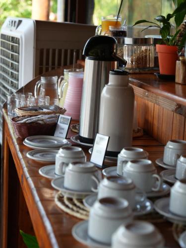 a table with cups and plates and a coffee pot at Pousada Pitauá in Socorro