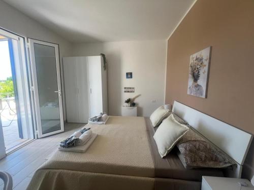 Un dormitorio con una cama grande y una puerta corrediza de vidrio. en Villa Gallieco, en Noto