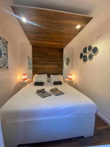 a large white bed in a room with two lights at Flat Graça 48 in Lisbon