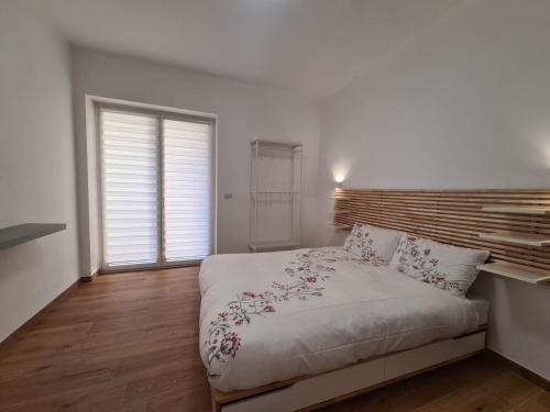 une chambre avec un lit blanc avec une tête de lit en bois dans l'établissement La Casa di Nonna, à Conversano