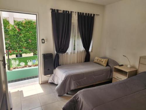 Un dormitorio con dos camas y una gran ventana. en Maktub Alta Gracia, Complejo para Turistas, en Alta Gracia