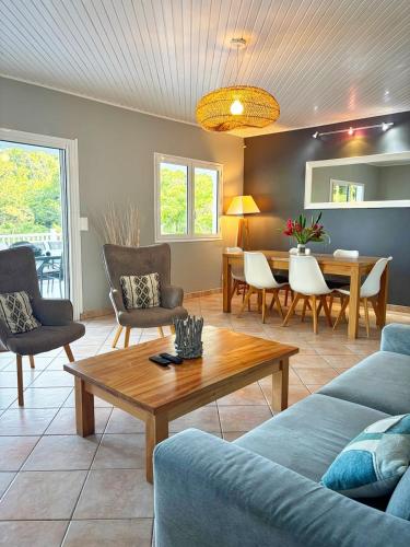 una sala de estar con un sofá y una mesa en Villa Migaline, stunning bay views, en Le Marin