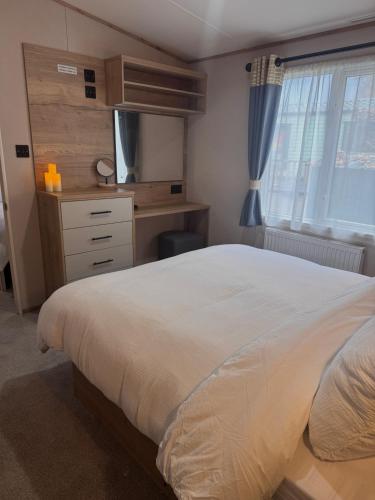 a bedroom with a bed and a desk and a television at Sheepfold lodge in Sedbergh