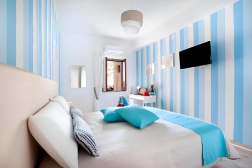 a bedroom with a bed with blue and white stripes at Mare Sunset & Relax in Meta