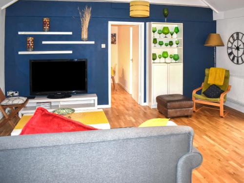 un soggiorno con un divano e una TV di Fawns Cottage a Culmstock